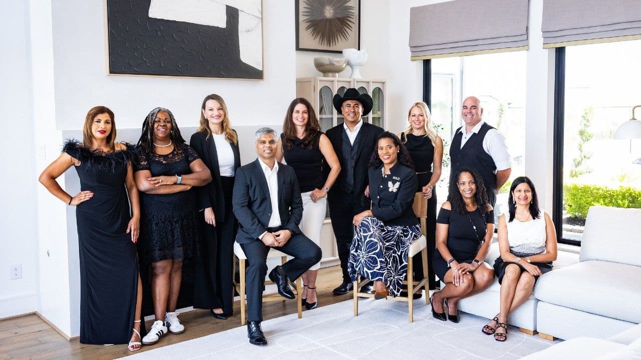 Keller Williams Southwest agents gathered in front of the market center step-and-repeat in Sugar Land